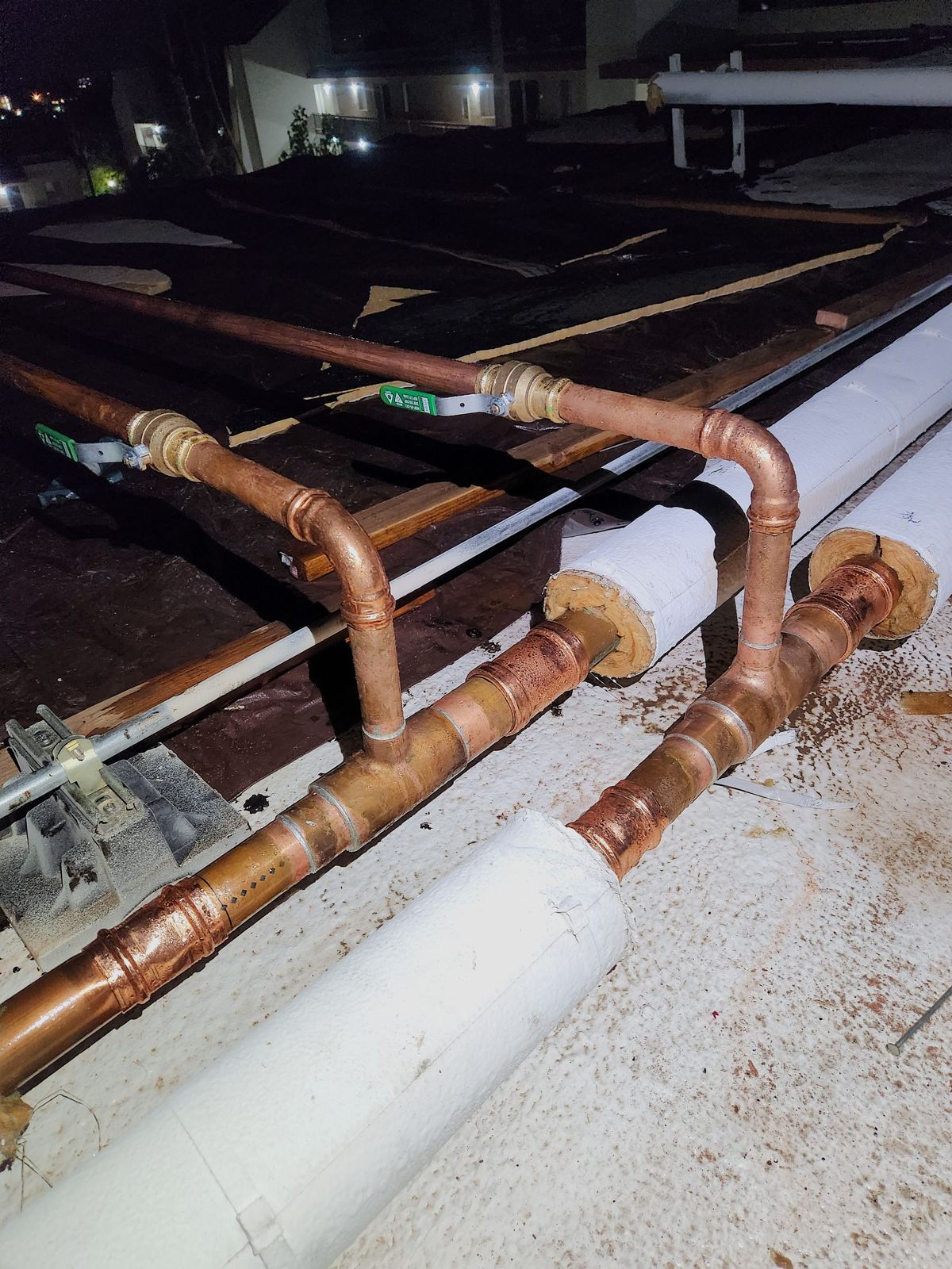 Large copper and steel pipe runs on a commercial wall