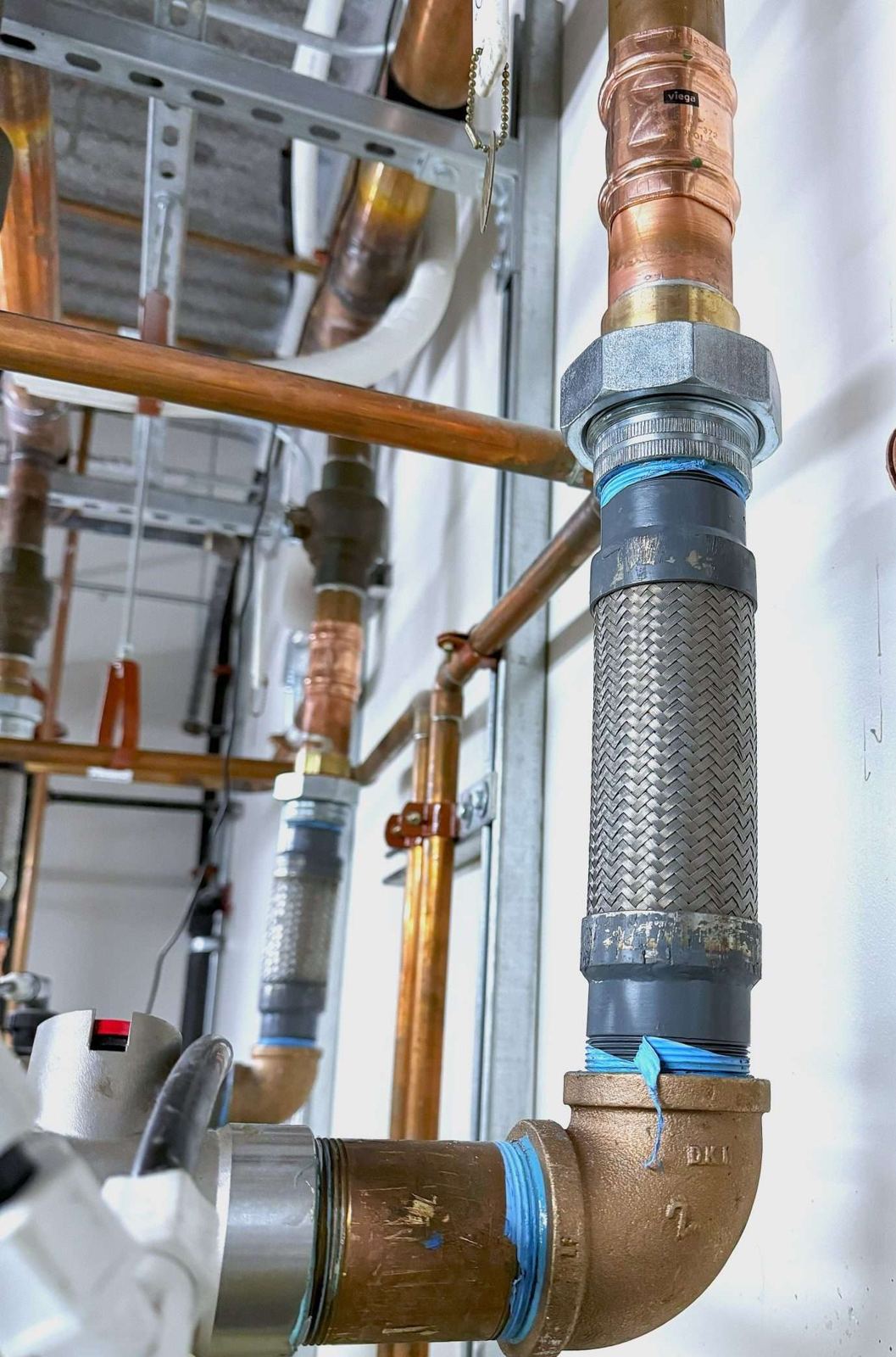 Copper elbow joining a large steel line